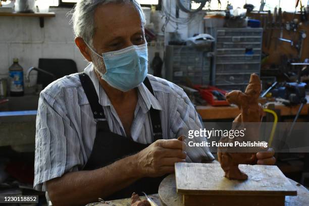 Guatemalan sculptor Edgar Guzman Schwartz performing of a sculpture makes of plasticine in his workshop in Tepoztlan, takes protective measures amid...
