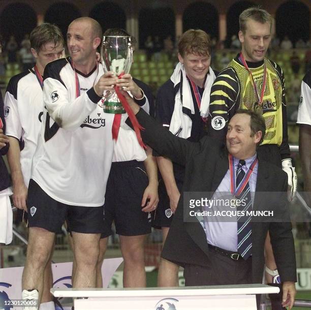 L'entraîneur du Liverpool FC, le français Gérard Houllier porte la super coupe d'Europe de football avec ses joueurs, le 24 août 2001 au stade Louis...