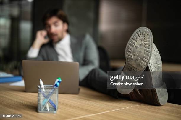 nahaufnahme der sohle von schuhen eines entspannten geschäftsmannes im büro. - sole of shoe stock-fotos und bilder