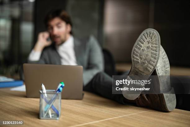 close up of sole of shoes of a relaxed businessman in the office. - legs on the table stock pictures, royalty-free photos & images