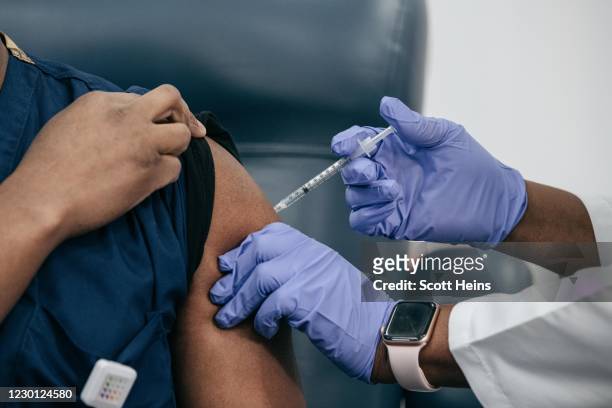 Lenox Hill Hospital Chair of Emergency Medicine Yves Duroseau receives the COVID-19 vaccine from Doctor Michelle Chester at Long Island Jewish...