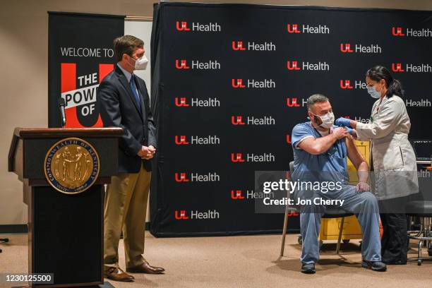 Kentucky Governor Andy Beshear watches as Dr. Jason Smith receives a COVID-19 vaccination at the University of Louisville Hospital on December 14,...