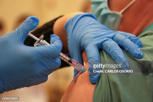 Derek Thompson, a personal support worker, is inoculated with the Pfizer/BioNTEch coronavirus disease vaccine at The Michener Institute, in Toronto,...