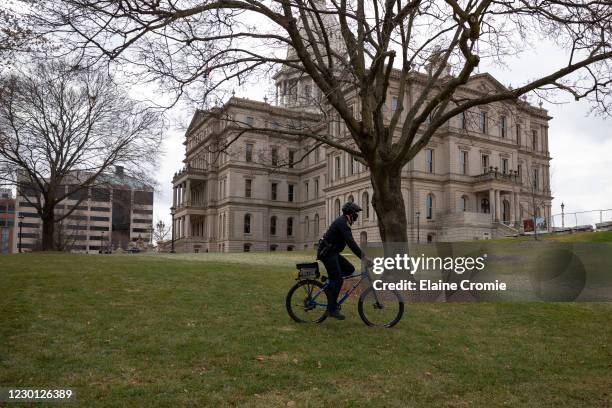 Police patrol outside the Michigan State Capitol as pro-Trump demonstrators protest nearby on December 14, 2020 in Lansing, Michigan. Michigan...