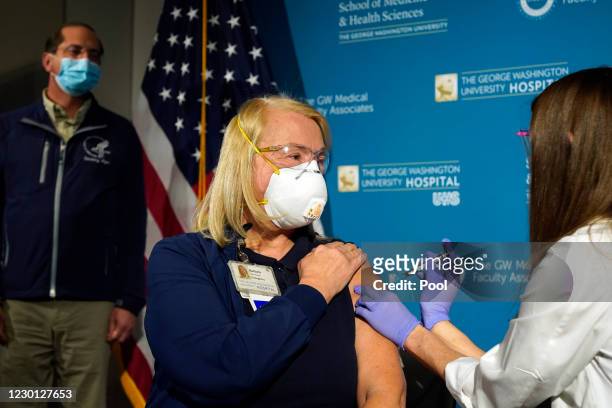 Nurse Lillian Wirpsza administers a COVID-19 vaccine to emergency department nurse Barbara Neiswander at George Washington University Hospital on...