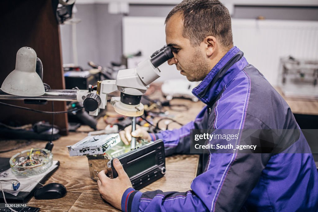 One young mechanic repairing car stereo system