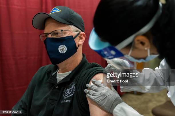 Acting Secretary of Defense Christopher Miller gets his first shot of the Pfizer-BioNTech COVID-19 vaccine, administered by HN Samantha Alvarez, at...