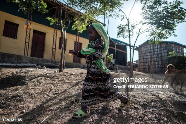 Girl runs in the village of Bisober, in Ethiopia's Tigray region on December 9, 2020. - The November 14 killings represent just one incident of...