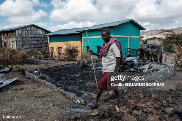 Addis Sissay walks in front of his destroyed house in the village of Bisober, in Ethiopia's Tigray region on December 9, 2020. The November 14...