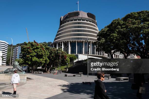 Pedestrians walk past the Parliament Building in Wellington, New Zealand, on Tuesday, Dec. 15, 2020. New Zealand has eliminated community...