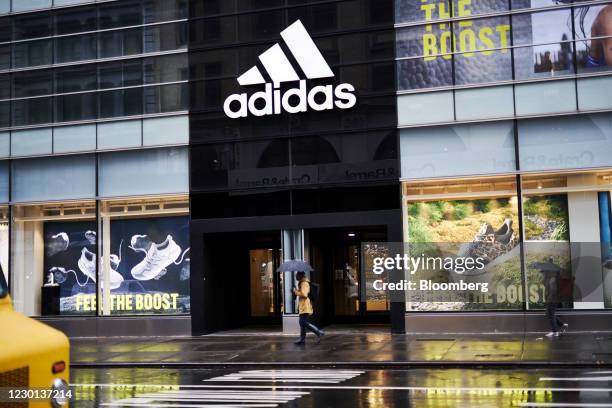 Pedestrian carrying an umbrella passes in front of an Adidas AG store in the SoHo neighborhood of New York, U.S., on Monday, Dec. 14, 2020. The U.S....