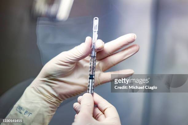 Rocky Mountain Regional VA Medical Center investigational pharmacy technician Sara Berech prepares a dose of the Johnson & Johnson COVID-19 vaccine...