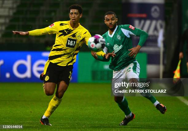 Bremen's German midfielder Jean-Manuel Mbom and Dortmund's English midfielder Jude Bellingham vie for the ball during the German first division...