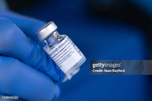 Nurse shows off a vial of the Pfizer-BioNTech COVID-19 vaccine outside of the Chatham County Health Department on December 15, 2020 in Savannah,...