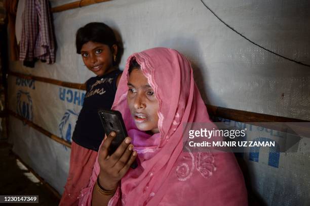 In this photograph taken on October 8 Rohingya refugee Arofa Khatun, who tried to migrate with her two children to Malaysia to her husband, interacts...