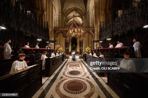 Daniel Cook, Master of the Choristers and Organist at Durham Cathedral, conducts the members of the cathedral choir as they practice before recording...