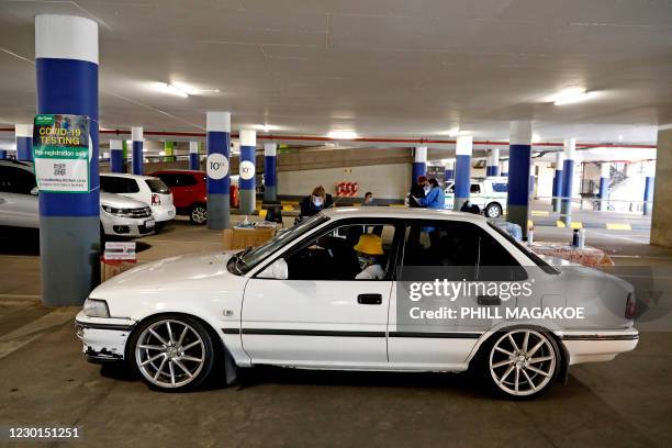 Dis-Chem Pharmacy health professionals prepare to collet nasal swabs from people queueing inside their vehicle for a COVID-19 coronavirus test at a...