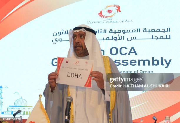 President of the Olympic Council of Asia Ahmad al-Fahad al-Sabah holds a placard announcing Doha as the host of the 21st Asian Games 2030 during the...