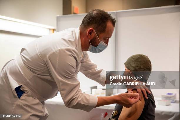 Jeff Doucette, Chief Nursing Officer at Jefferson Health, administers a Covid-19 vaccine to Mark Nicolas, a nurse at Jefferson Health's Cherry Hill...