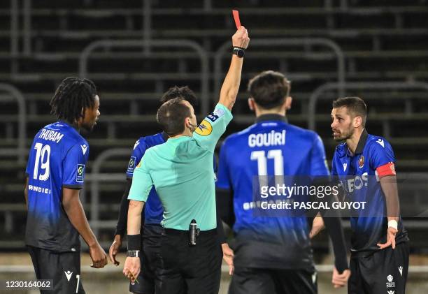 French referee Ruddy Buquet gives a red card to Nice's French midfielder Morgan Schneiderlin during the French L1 football match between Nimes...
