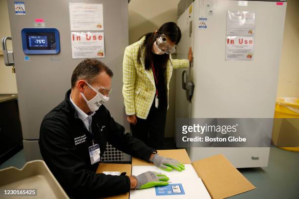 Luca Cattaneo, Registered Pharmacist at Beth Israel Deaconess Medical Center opens a box containing the Pfizer/BioNTech vaccine as Pharmacist...