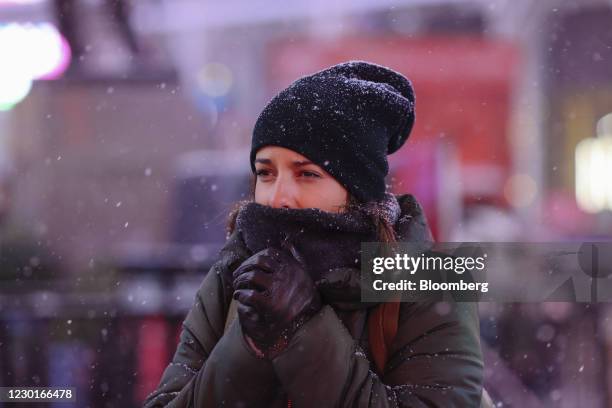 Pedestrian waits to cross a street as snow falls in the Times Square neighborhood of New York, U.S., on Wednesday, Dec. 16, 2020. A major winter...