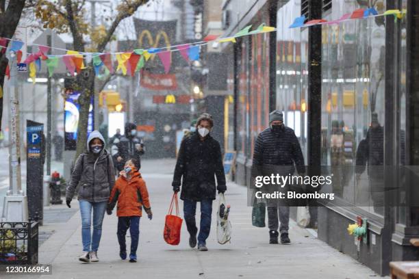 Pedestrians walk along a street as snow falls in the Chelsea neighborhood of New York, U.S., on Wednesday, Dec. 16, 2020. A major winter storm is...