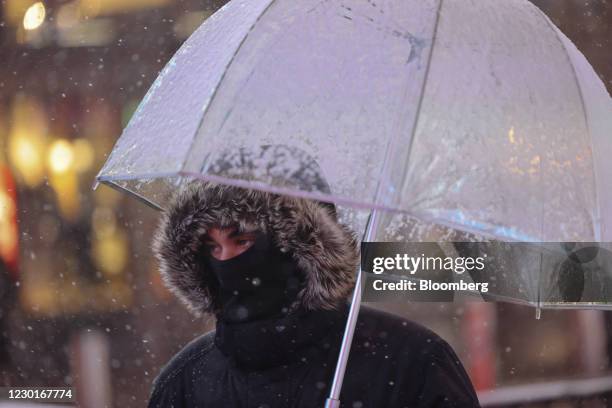 Pedestrian holds an umbrella as snow falls in the Times Square neighborhood of New York, U.S., on Wednesday, Dec. 16, 2020. A major winter storm is...