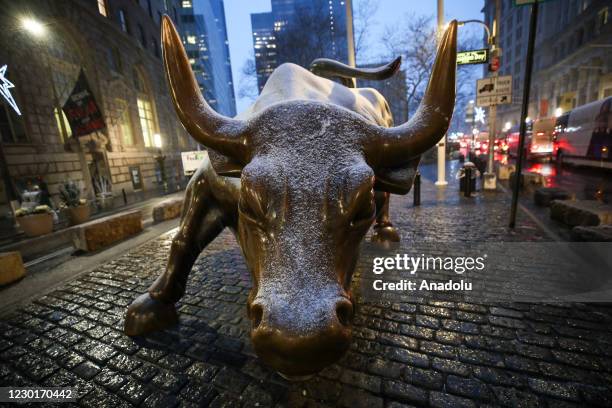 Charging Bull Statue is seen at the Financial District as snowfall in New York City, United States on December 16, 2020. New York is ranked as one of...
