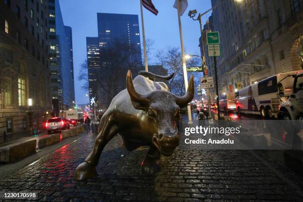 Charging Bull Statue is seen at the Financial District as snowfall in New York City, United States on December 16, 2020. New York is ranked as one of...