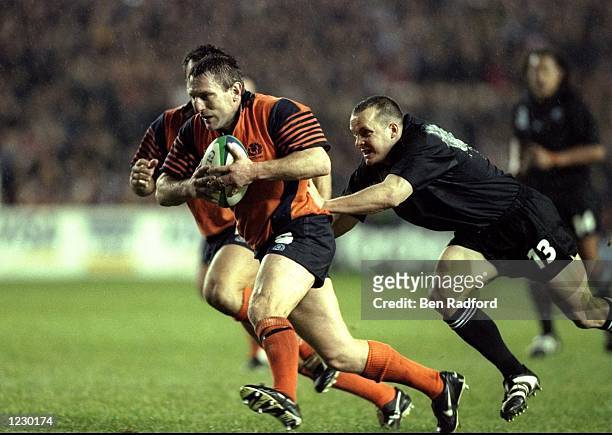 Gary Armstrong of Scotland is tackled by Christain Cullen of New Zealand during the Rugby World Cup Quarter Final played at Murrayfield, Edinburgh,...