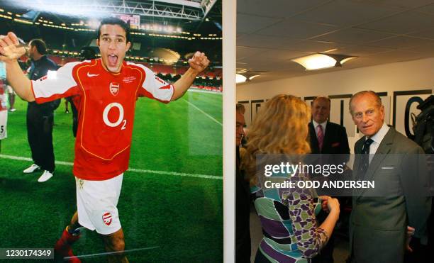 Britain's Prince Philip meets employees in the Learning Centre at Arsenal football club beside a poster of player Robin van Persie as he officially...