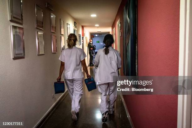 Medical workers carry cold storage boxes containing injection material to the laboratory during a phase 3 trial of the Johnson & Johnson Covid-19...