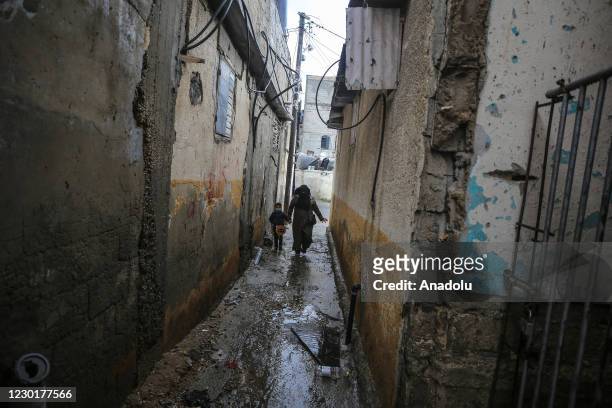 Palestinians walk in a narrow street under difficult conditions at Jabalia refugee camp, in Gaza City, Gaza on December 17, 2020. The number of...