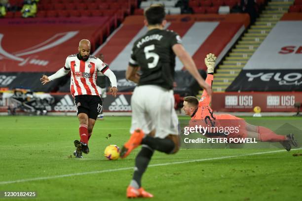 Sheffield United's English-born Irish striker David McGoldrick shoots to score the opening goal Manchester United's English goalkeeper Dean Henderson...