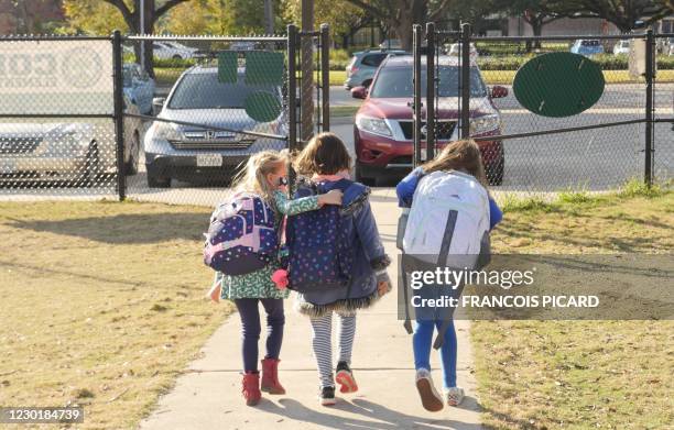 School children wearing facemasks walk outside Condit Elementary School in Bellaire, outside Houston, Texas, on December 16, 2020. - The coronavirus...