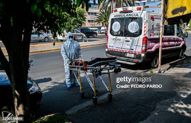 Paramedic pushes a stretcher to take a man with symptoms of COVID-19 an ambulance before transferring him to a hospital in Ciudad Nezahualcoyotl,...