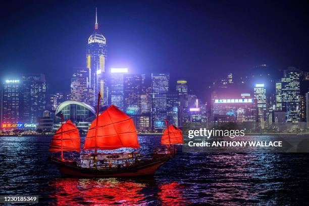 In this picture taken on November 27 a traditional wooden tourist junk boat "Dukling" sails in the waters of Victoria Harbour in Hong Kong, which was...