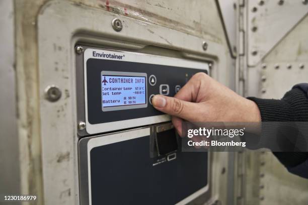 Worker uses the control pad of an Envirotainer, a temperature-cooled container, at the SATS Ltd. Coolport handling center at Changi Airport in...