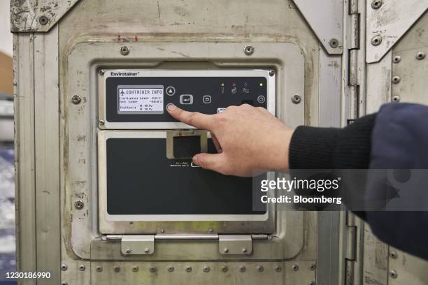 Worker uses the control pad of an Envirotainer, a temperature-cooled container, at the SATS Ltd. Coolport handling center at Changi Airport in...