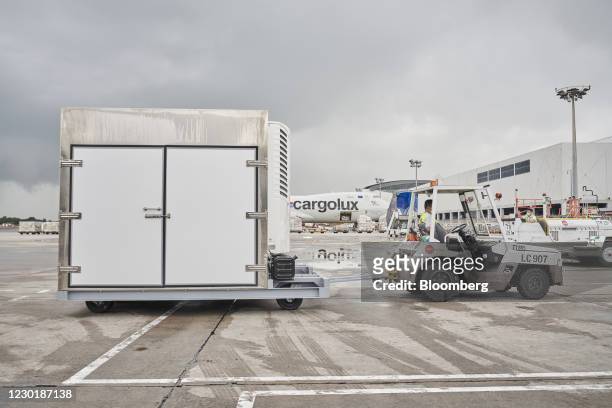 Ltd. Workers tow a cool dolly at Changi Airport in Singapore, on Wednesday, Dec. 16, 2020. SATS is preparing for the arrival of its first shipment of...