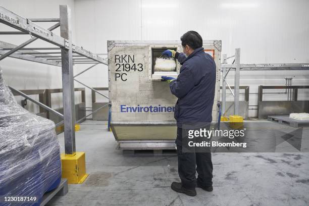 Worker opens the hatch of an Envirotainer, a temperature-cooled container, at the SATS Ltd. Coolport handling center at Changi Airport in Singapore,...