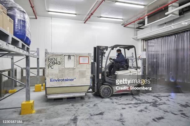 Worker uses a forklift to move an Envirotainer, a temperature-cooled container, at the SATS Ltd. Coolport handling center at Changi Airport in...