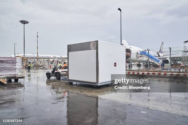 Ltd. Workers tow a cool dolly at Changi Airport in Singapore, on Wednesday, Dec. 16, 2020. SATS is preparing for the arrival of its first shipment of...