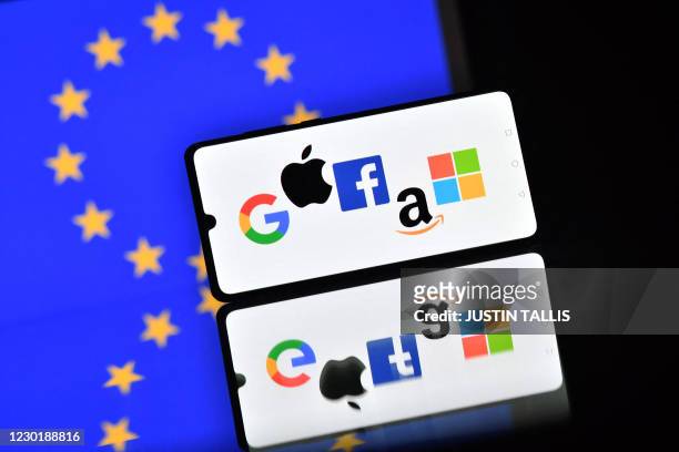 An illustration picture taken in London on December 18, 2020 shows the logos of Google, Apple, Facebook, Amazon and Microsoft displayed on a mobile...