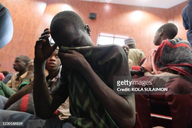 Distressed child covers his face while gathering at the Government House with other students from the Government Science Secondary school, in...