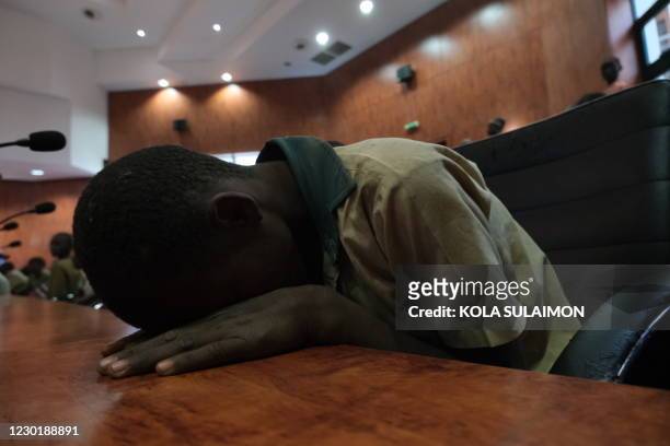 Distressed child leans on the desk while gathering at the Government House with other students from the Government Science Secondary school, in...