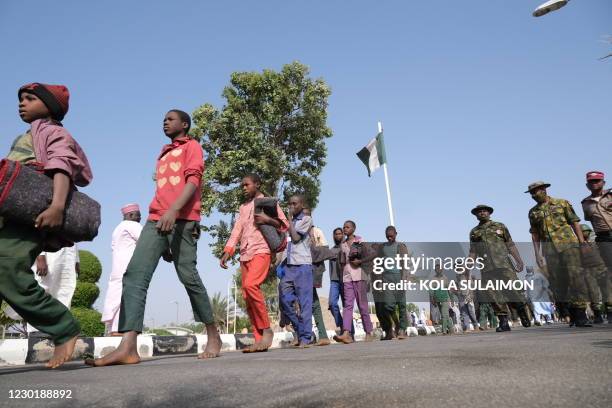 Released students from the Government Science Secondary school, in Kankara, in northwestern Katsina State, Nigeria are led into the Government House...