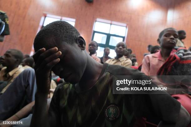Distressed child covers his face while gathering at the Government House with other students from the Government Science Secondary school, in...