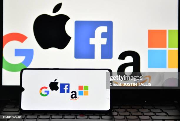 An illustration picture taken in London on December 18, 2020 shows the logos of Google, Apple, Facebook, Amazon and Microsoft displayed on a mobile...